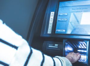 Woman using cash machine-ATM,close up view.